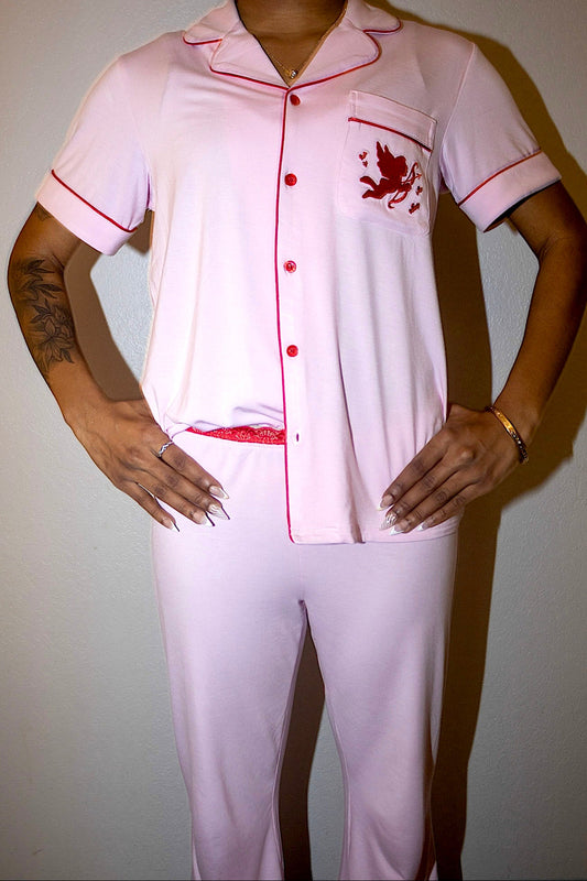 Person wearing a white pajama set with red accents and a red dragon design on a plain background